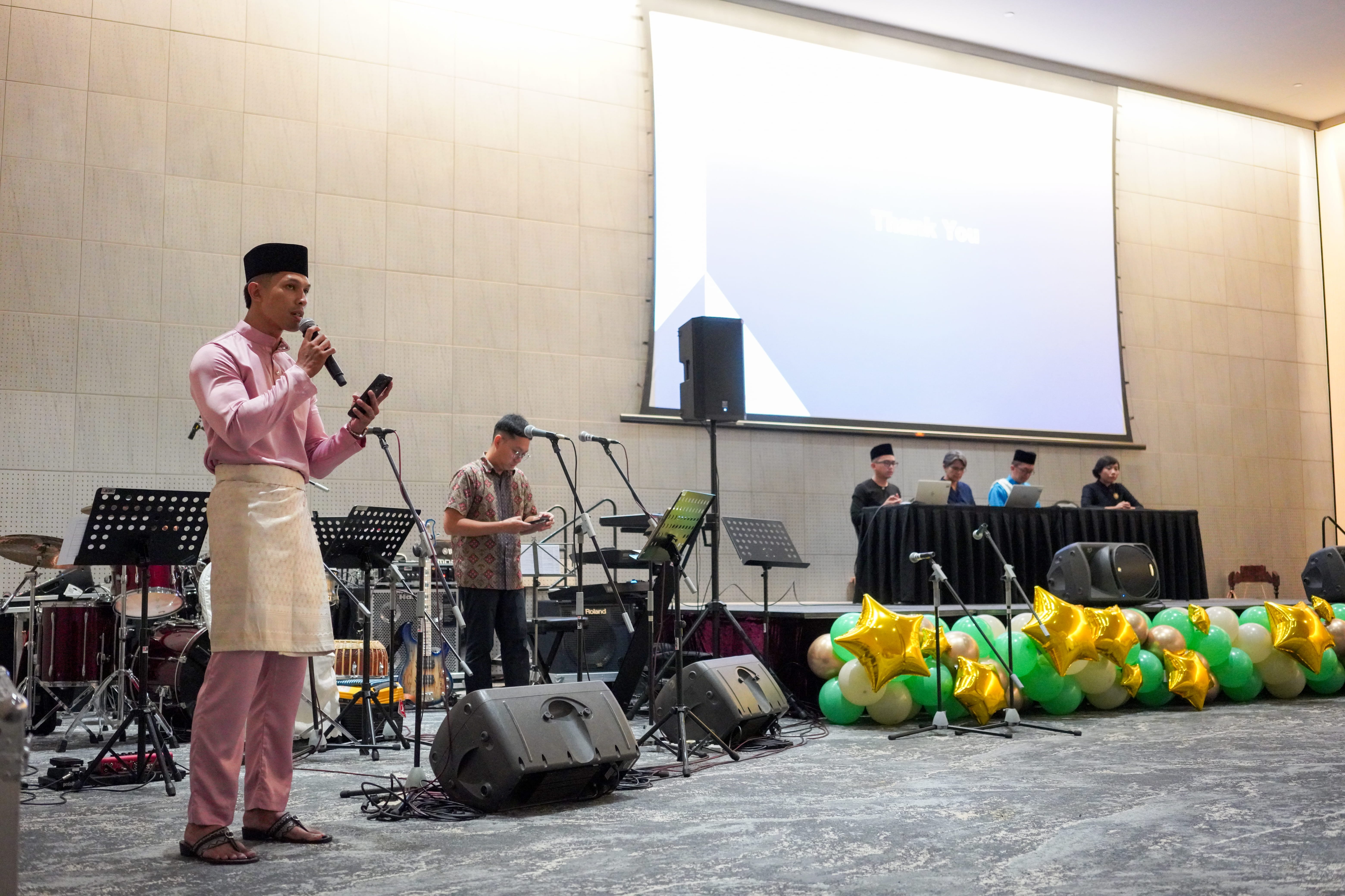 A speaker addresses attendees during the 69th Annual General Meeting while the meeting panel remains seated at the front of the hall.